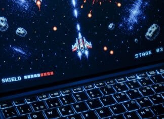 Laptop z retro strzelanką kosmiczną w stylu pixel art
