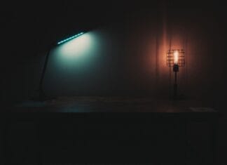 Lampy z zimnym i ciepłym światłem na stole w ciemnym pokoju