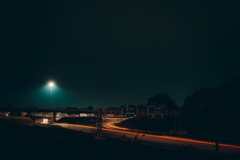 Nocna autostrada w Indianapolis ze smugami świateł i znakami drogowymi
